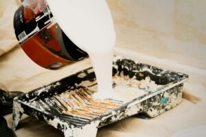 Person Pouring White Paint on Container