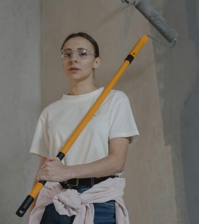 Woman in White Crew Neck T-shirt Holding a Paint Roller